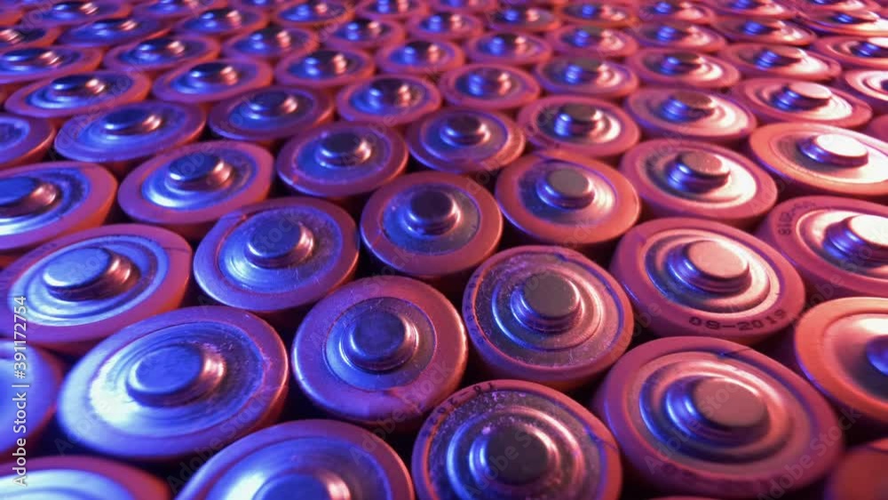 Many old alkaline batteries illuminated by a red lamp. Many old alkaline batteries illuminated by a red lamp.