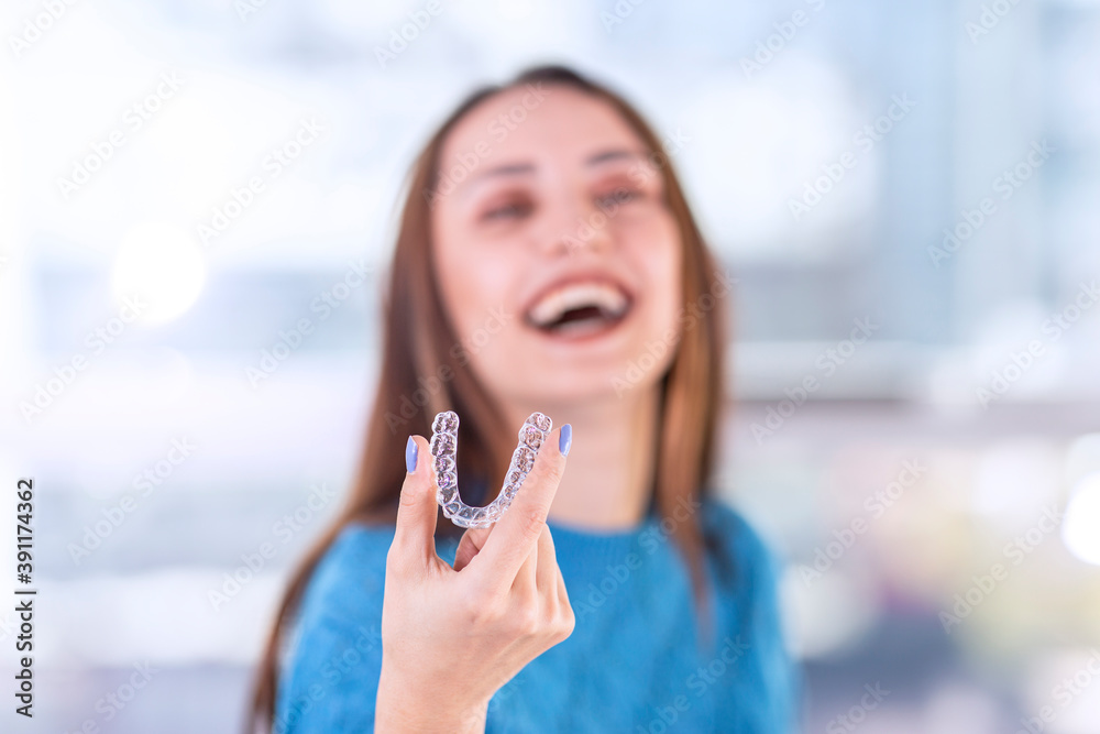 custom made wallpaper toronto digitalBeautiful smiling Turkish woman is holding an invisalign bracer, includes copy space