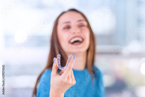 Wallpaper Mural Beautiful smiling Turkish woman is holding an invisalign bracer, includes copy space Torontodigital.ca