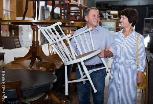 Happy couple is shopping the old armchair in the antique store © JackF
