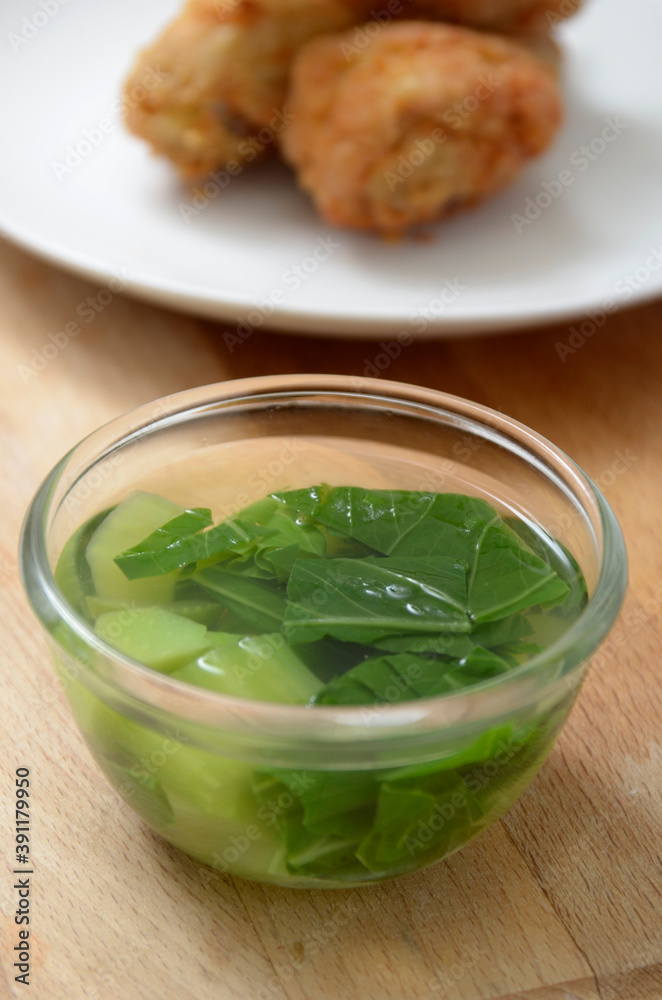vegetables soup, pok coy and chayote, with fried chicken as a background vegetables soup, pok coy and chayote, with fried chicken as a background