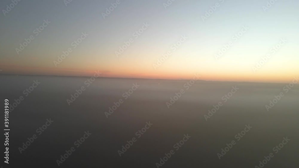 Drone ascending out of thick fog to a sunrise in the open plains. Drone ascending out of thick fog to a sunrise in the open plains.