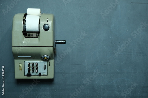 Vecchia calcolatrice su sfondo lavagna con gessettie spazio per scrivere testo photo