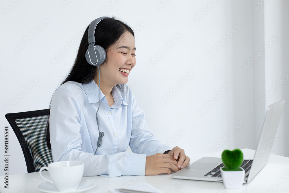 Young white Asian woman studying via the internet in her home office. Young white Asian woman studying via the internet in her home office.