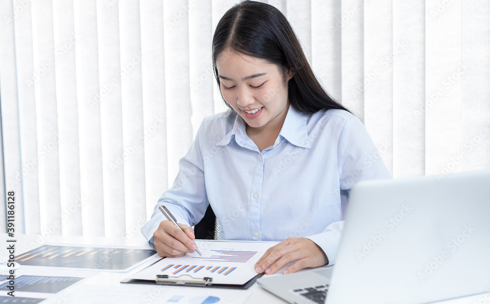 Asian finance woman analyzing data on graphs Asian finance woman analyzing data on graphs