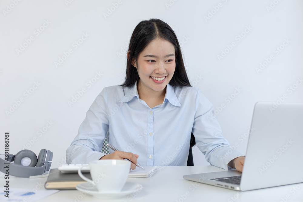Young white Asian woman studying via the internet in her home office. Young white Asian woman studying via the internet in her home office.