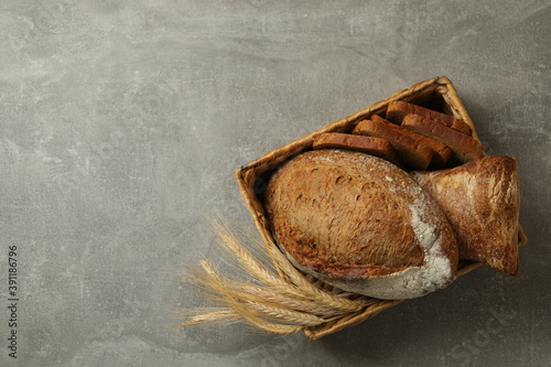 Basket with fresh bread on gray table