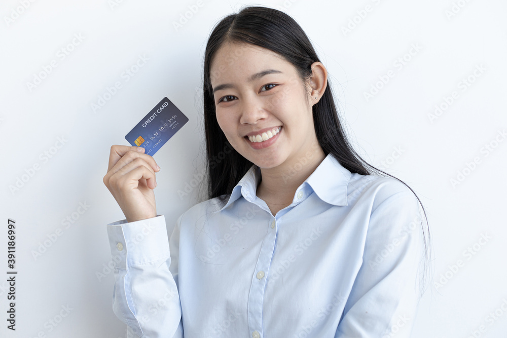 White Asian woman holding a credit card and smiling bright White Asian woman holding a credit card and smiling bright