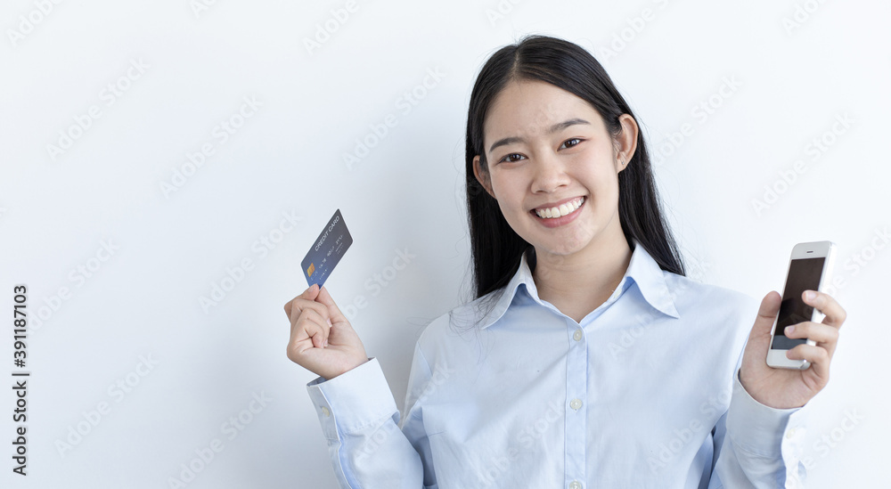 White Asian woman holding a credit card and smiling bright White Asian woman holding a credit card and smiling bright