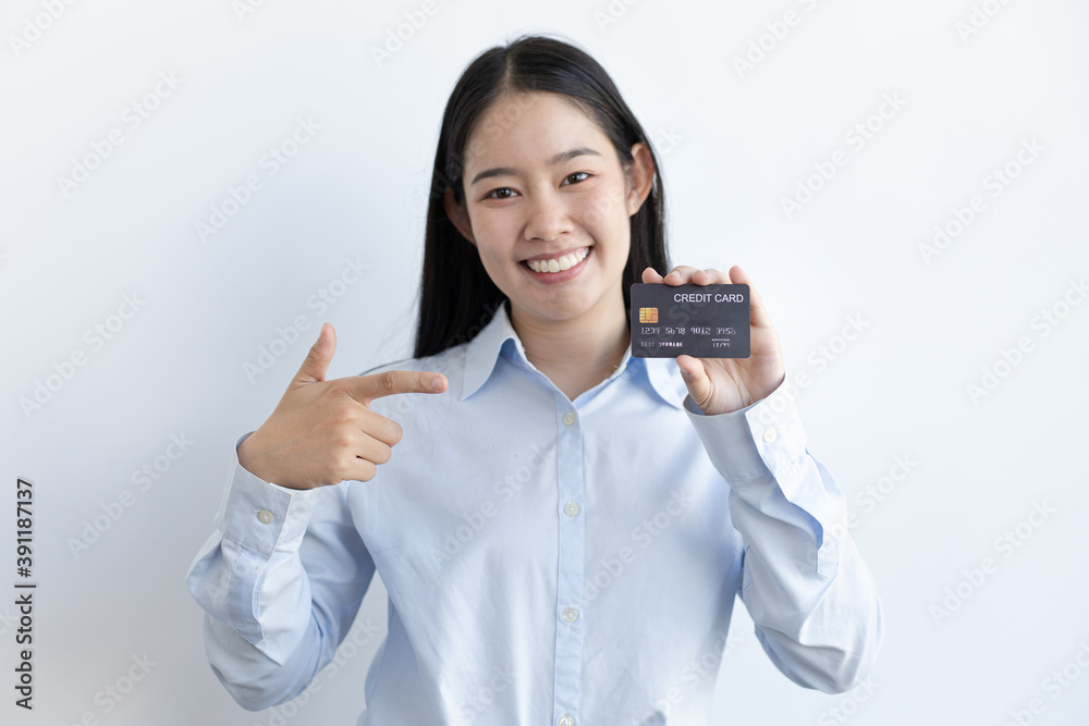 White Asian woman holding a credit card and smiling bright White Asian woman holding a credit card and smiling bright