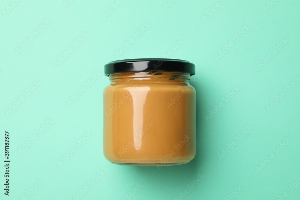 Blank jar with peanut butter on mint background Blank jar with peanut butter on mint background