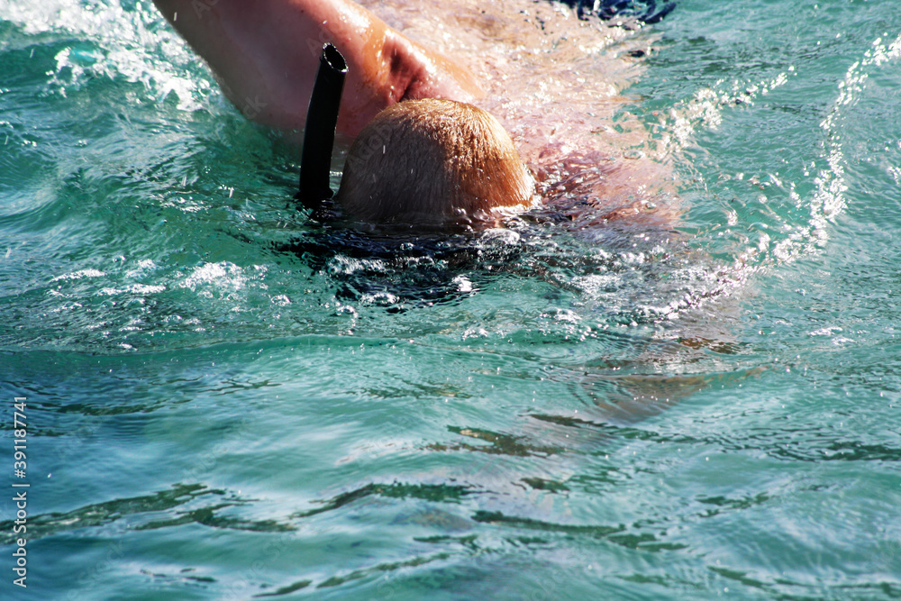 Man with snorkeling mask swimming in the sea