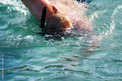 Man with snorkeling mask swimming in the sea