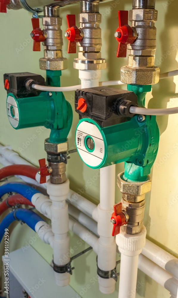 Pumps, shut-off equipment and polypropylene pipes close - up on a wall background