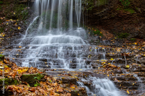 Colorful majestic waterfall in national park forest during autumn