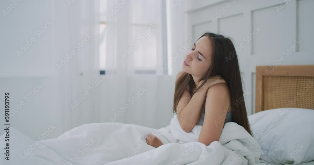Woman waking up and having pain in shoulder and neck. Upset woman waking up in bed feeling neck back pain Woman waking up and having pain in shoulder and neck. Upset woman waking up in bed feeling neck back pain