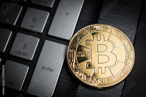Golden coin with a symbol of Bitcoin cryptocurrency (BTC) on computer keyboard: press the Enter to accept the electronic payment