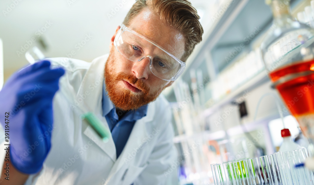 Research scientist looking at reaction in test tube in laboratory Research scientist looking at reaction in test tube in laboratory