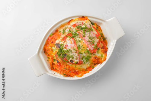 Italian lasagna served in a white pot over white background. Delicioud dinner concept, Italian cuisine. photo