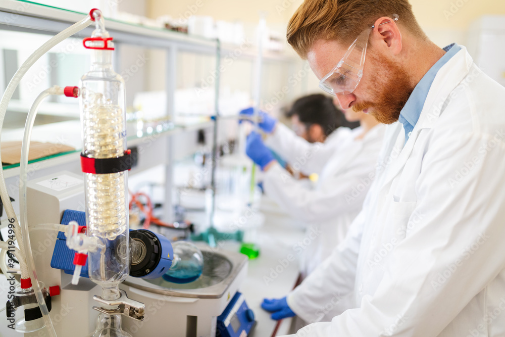 Serious clinicians studying chemical elements in laboratory Serious clinicians studying chemical elements in laboratory