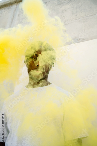 Young black man with a yellow smoke