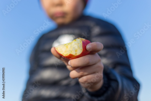 Outdoor picnic holding an apple in hand