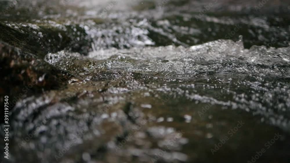 Slow motion of wild mountain river abundant clear stream flowing through rocks. Close-up of river rocks with flowing water. Close up Slow motion of wild mountain river abundant clear stream flowing through rocks. Close-up of river rocks with flowing water. Close up