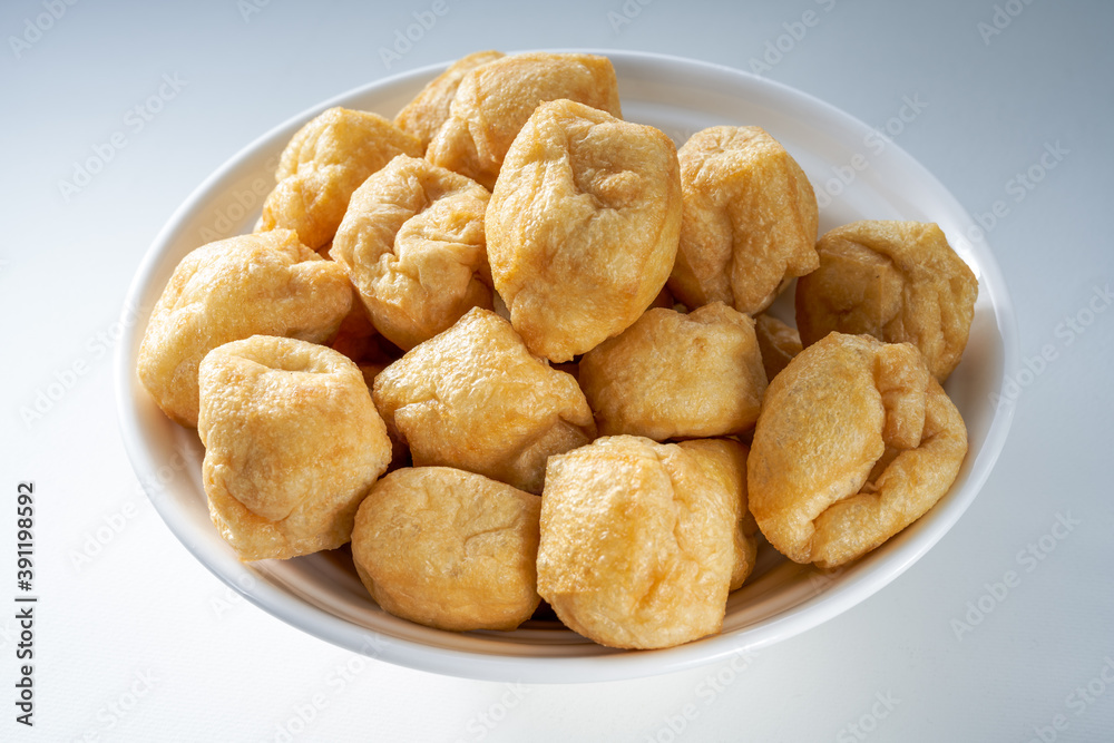 Close-up of a bowl of golden tempting fried tofu with avocado oil