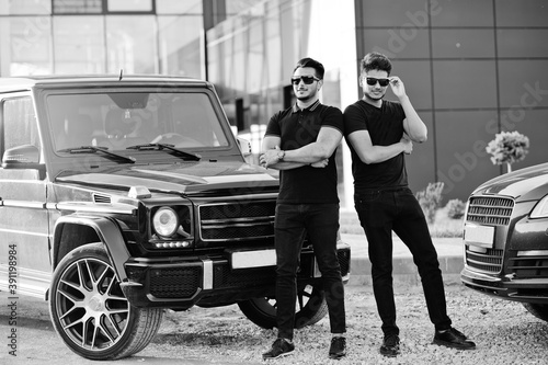 Two asian brothers man wear on all black posed near suv cars. © AS Photo Family
