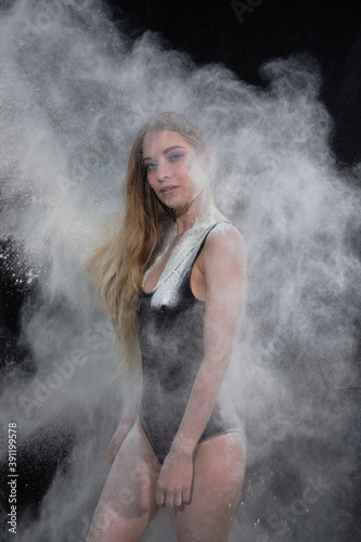 Portrait of a girl in a black bodysuit with flour