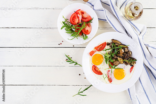 Tasty  breakfast - fried eggs, forest mushrooms, tomatoes and arugula. Lunch food. Top view, overhead, copy space