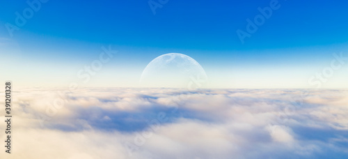 Panorama of the blue clear sky with the Moon above the thick white clouds in a gentle glowing haze