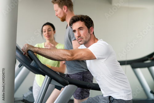 Group of people at the gym exercising on the cardio machines
