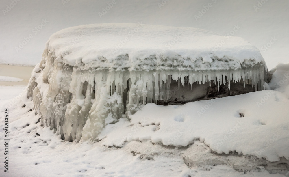 Icicles and frost on a snow-covered frozen river Icicles and frost on a snow-covered frozen river