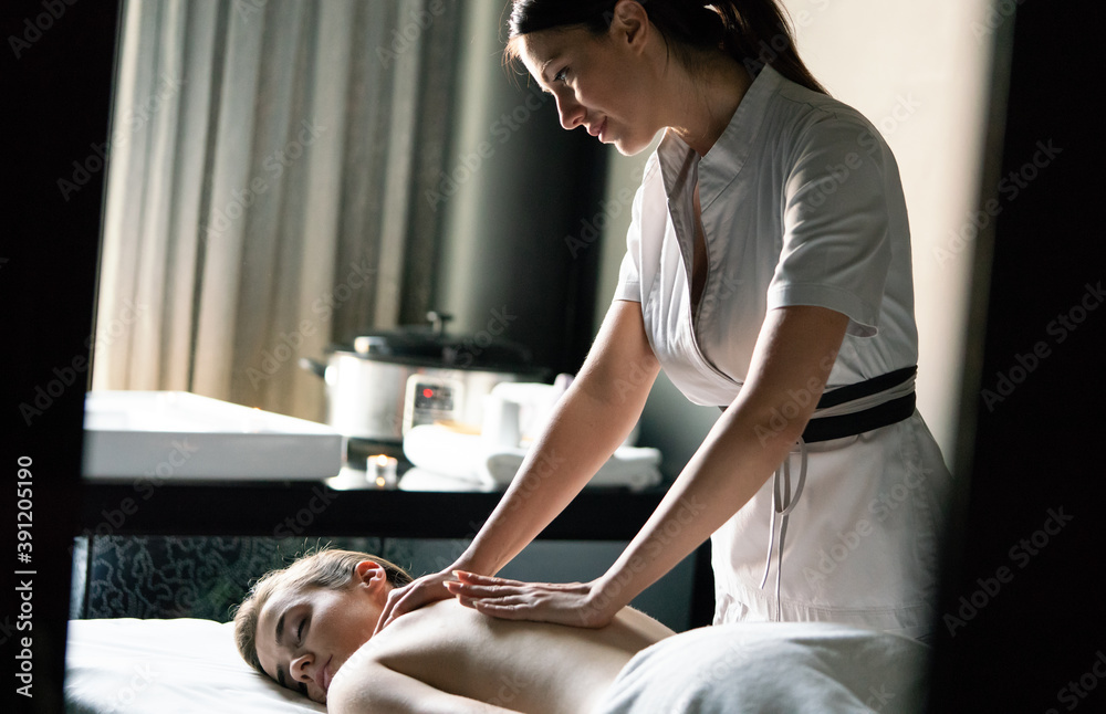 Beautiful young woman getting spa massage treatment at beauty spa salon