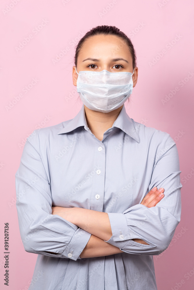Portrait of young woman in mask looking at camera, on pink background. Flu epidemic, dust allergy, virus protection. Portrait of young woman in mask looking at camera, on pink background. Flu epidemic, dust allergy, virus protection.