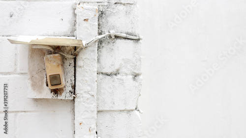 Old electric door bell on white wall