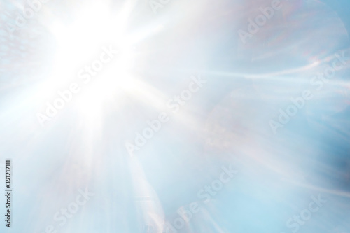 Blue blurred background with sun rays.