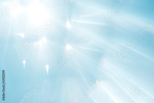 Blue blurred background with sun rays.