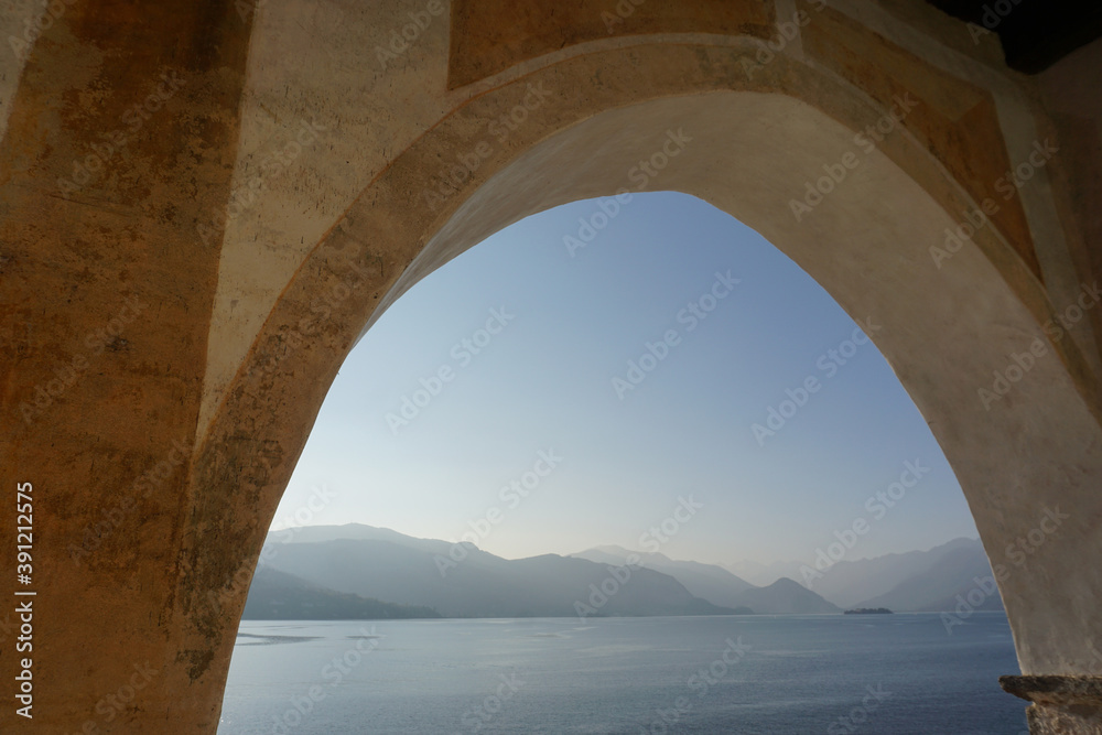 view of  lake Maggiore, Ticino from an old monastery arch window at sunset