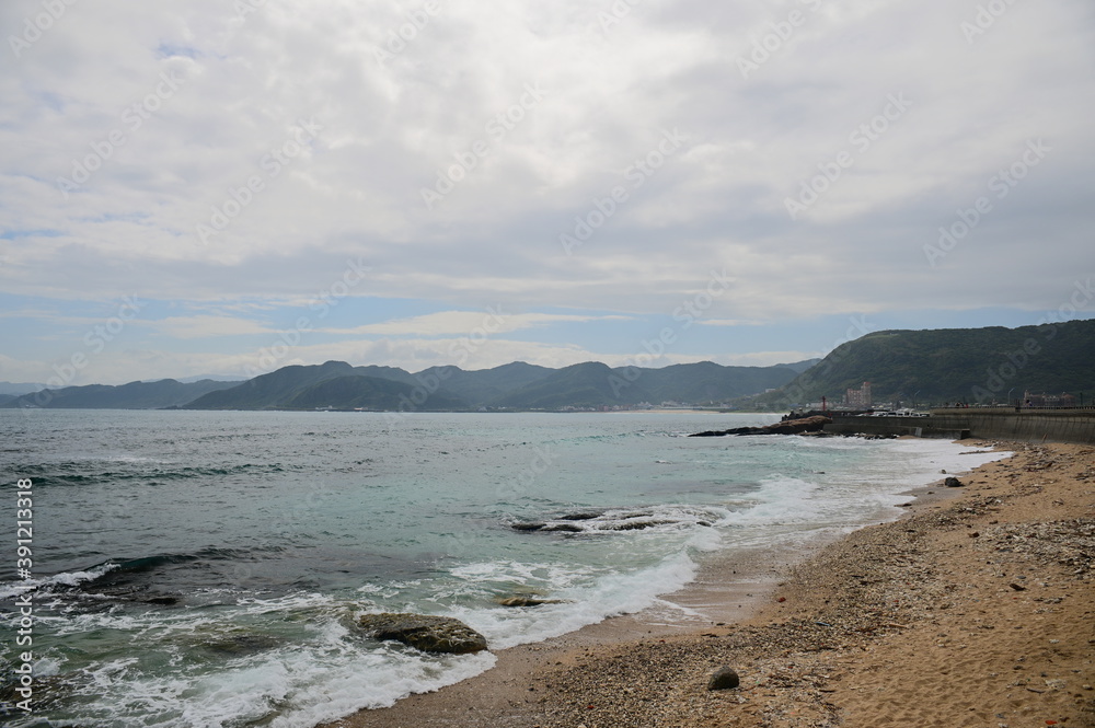 Watching waves beating against the coast at the Guihou Beach, overlooking the blue sky and white clouds in the distance. Watching waves beating against the coast at the Guihou Beach, overlooking the blue sky and white clouds in the distance.