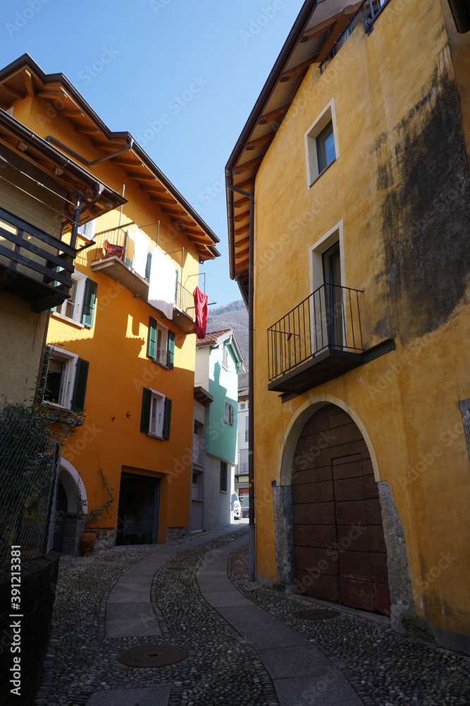 old cobblestone street in between colorful buildings in Ticino