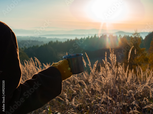 girl hold mug of tea in mountains Beskides in November in sunset