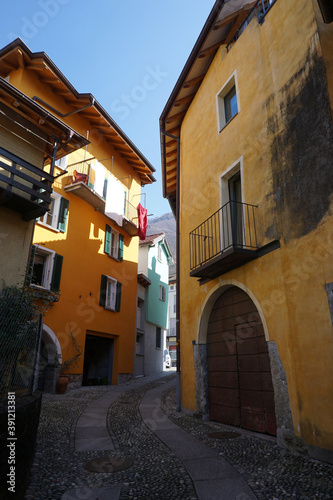 old cobblestone street in between colorful buildings in Ticino © poupine