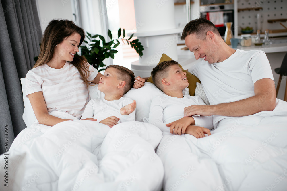 Young family enjoying in bed. Happy parents with sons relaxing in bed... Young family enjoying in bed. Happy parents with sons relaxing in bed...