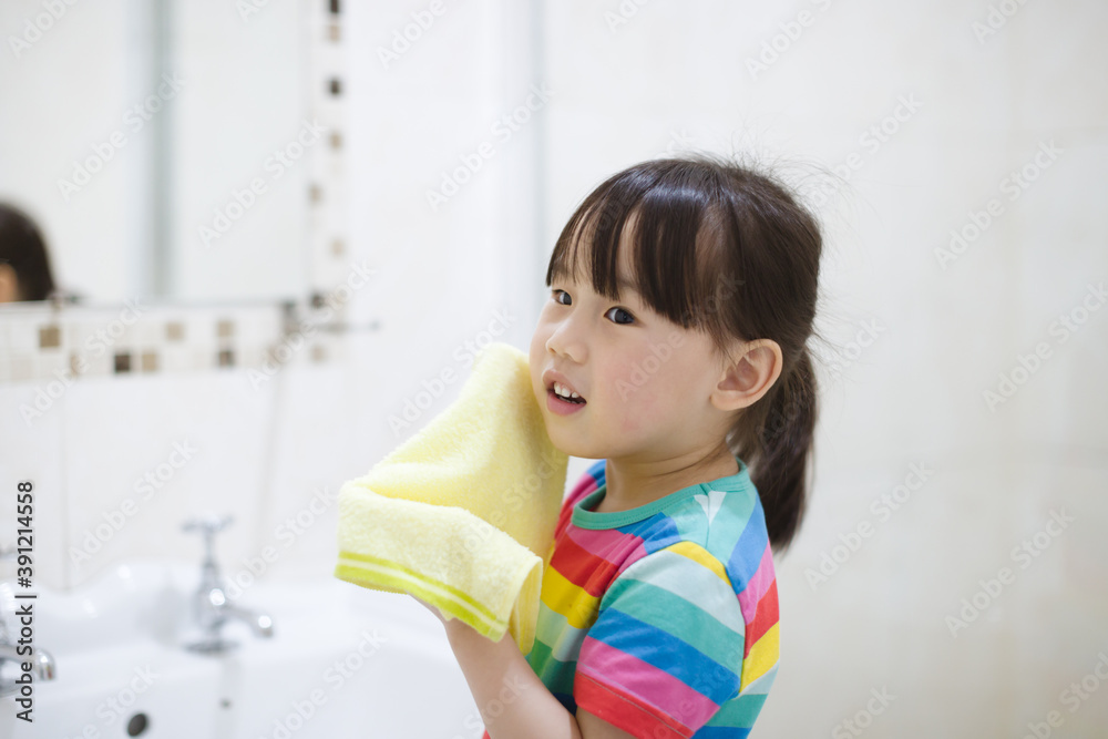young girl washing face by herself  in bathroom