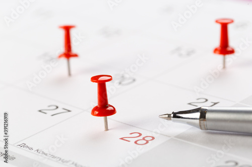 red buttons on the calendar. Concept idea for planning. An important date, business trip, or meeting reminder.