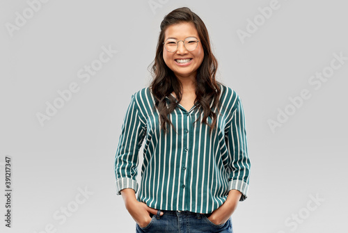 Obraz na plátně people, education and school concept - happy asian woman in glasses or student o