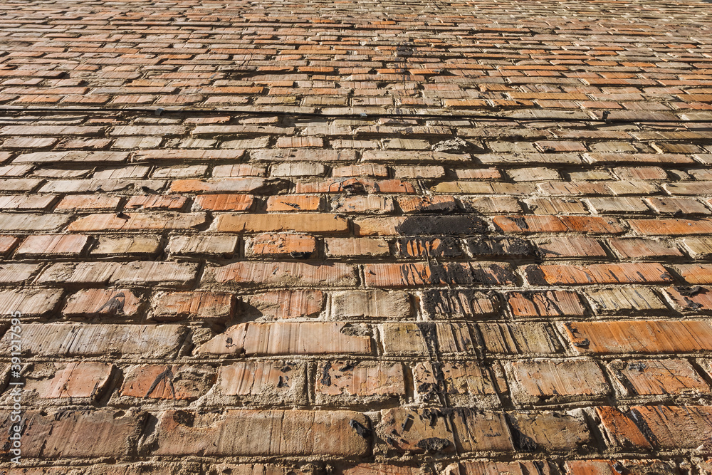 Brick wall background. Texture of an old brick wall with resin stains. Bottom view, perspective Brick wall background. Texture of an old brick wall with resin stains. Bottom view, perspective