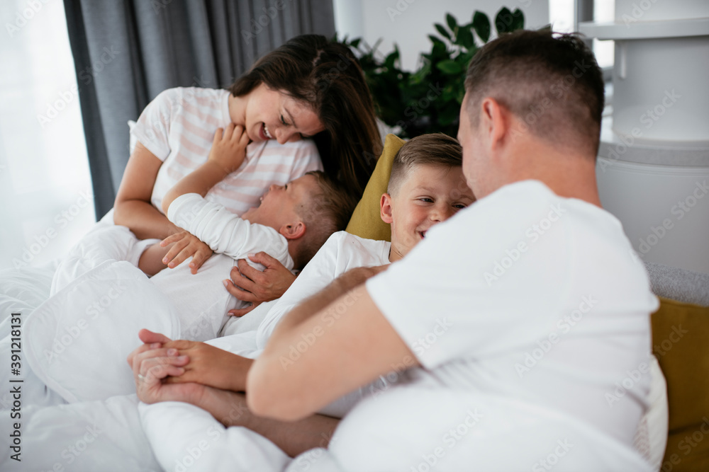 Young family enjoying in bed. Happy parents with sons relaxing in bed... Young family enjoying in bed. Happy parents with sons relaxing in bed...